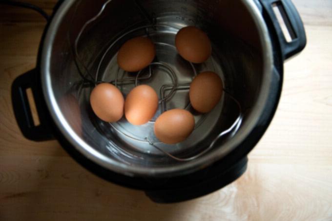Εύκολα Βραστά Αυγά σε 5 Λεπτά στην Instant Pot 4 Το Instant Pot 6 λίτρων IP Duo με 6 άβραστα αυγά και νερό στον εσωτερικό κάδο.