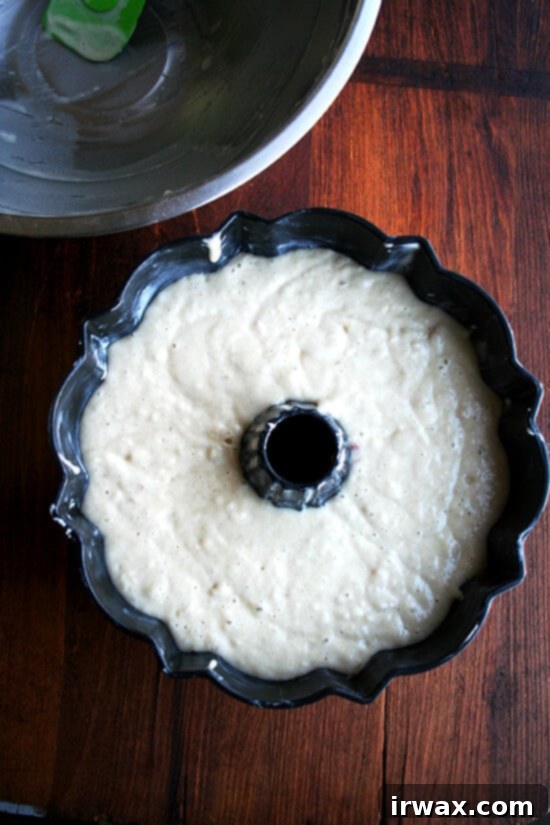 Ζουμερό Κέικ Μήλου 8 Φόρμα Bundt γεμάτη χυλό, έτοιμη για το φούρνο.