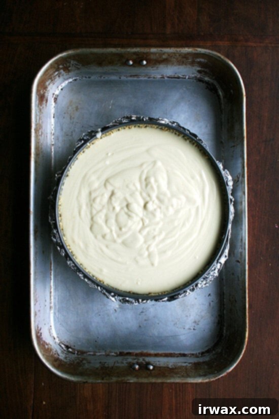 Τσιζκέικ με Λεμόνι και Ρικότα 9 Ταψί cheesecake γεμάτο με μείγμα, τοποθετημένο σε μεγαλύτερο ταψί, έτοιμο για μπεν μαρί.