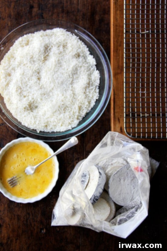 Τραγανή Μελιτζάνα Panko 4 Σταθμός παναρίσματος σε τραπέζι: τριμμένη φρυγανιά, αυγά, μελιτζάνα πασπαλισμένη με αλεύρι.