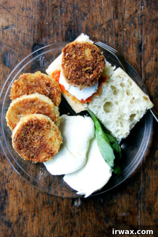 Τραγανή Μελιτζάνα Panko 9 Μια πιατέλα με τραγανές ροδέλες μελιτζάνας, ντομάτα, μοτσαρέλα, ψωμί και βασιλικό.