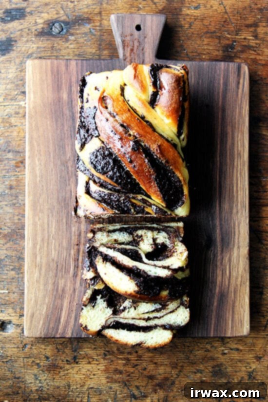 Λατρεύω αυτό το υβριδικό babka — δεν μπορώ να σταματήσω να το τρώω! — και μόλις τελειώσω το υπόλοιπο καρβέλι στον πάγκο μου, θα κλειδώσω όλα τα άλευρα και τα διογκωτικά μου και τη σοκολάτα, και θα βάλω ένα τέλος σε αυτή τη μανία ψησίματος μια για πάντα! // alexandracooks.com Ένα ξύλο κοπής με φρεσκοκομμένη babka σοκολάτα-πορτοκάλι