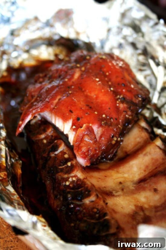 Αυτή η καταπληκτική συνταγή για baby back ribs χρειάζεται πέντε λεπτά προετοιμασίας, αλλά αυτό που βγαίνει από τον φούρνο – ένα ζουμερό πακέτο από baby back ribs που πέφτουν από το κόκαλο, τέλεια τραγανά εξωτερικά – έχει τη γεύση μιας ολόκληρης μέρας δουλειάς πάνω από μια ψησταριά γεμάτη κάρβουνα. Γλυκά. Καπνιστά. Αλμυρά. Νόστιμα. Αν αυτά δεν είναι τα καλύτερα παϊδάκια που έχετε ετοιμάσει ποτέ, είναι τουλάχιστον καταπληκτικά παϊδάκια. // alexandracooks.com Μαγειρεμένα παϊδάκια τυλιγμένα σε αλουμινόχαρτο, μόλις βγήκαν από τον φούρνο
