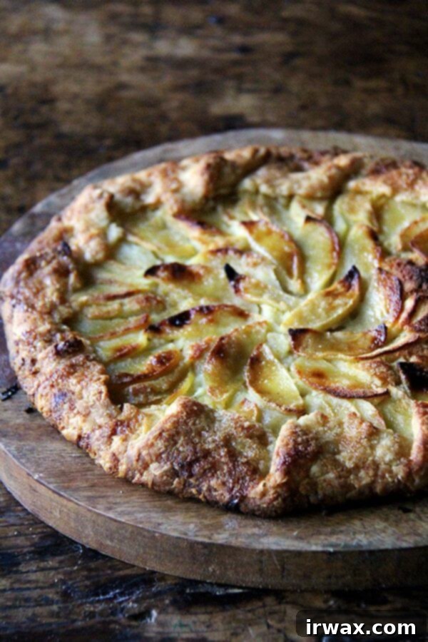 Η ζύμη αυτής της μηλόπιτας galette, η οποία είναι απίστευτα αφράτη, ελαφρώς γλυκιά και εντελώς νόστιμη, μπορεί να γίνει εξ ολοκλήρου στον πολυκόφτη, όπως και το φραντζιπάν — χωρίς να χρειάζεται να καθαρίσετε το μπολ μεταξύ των δραστηριοτήτων. Επιπλέον, ολόκληρη η galette μπορεί να συναρμολογηθεί και να μπει στον φούρνο σας σε περίπου 15 λεπτά. // alexandracooks.com Μηλόπιτα galette με φραντζιπάν σε ένα δίσκο σερβιρίσματος.