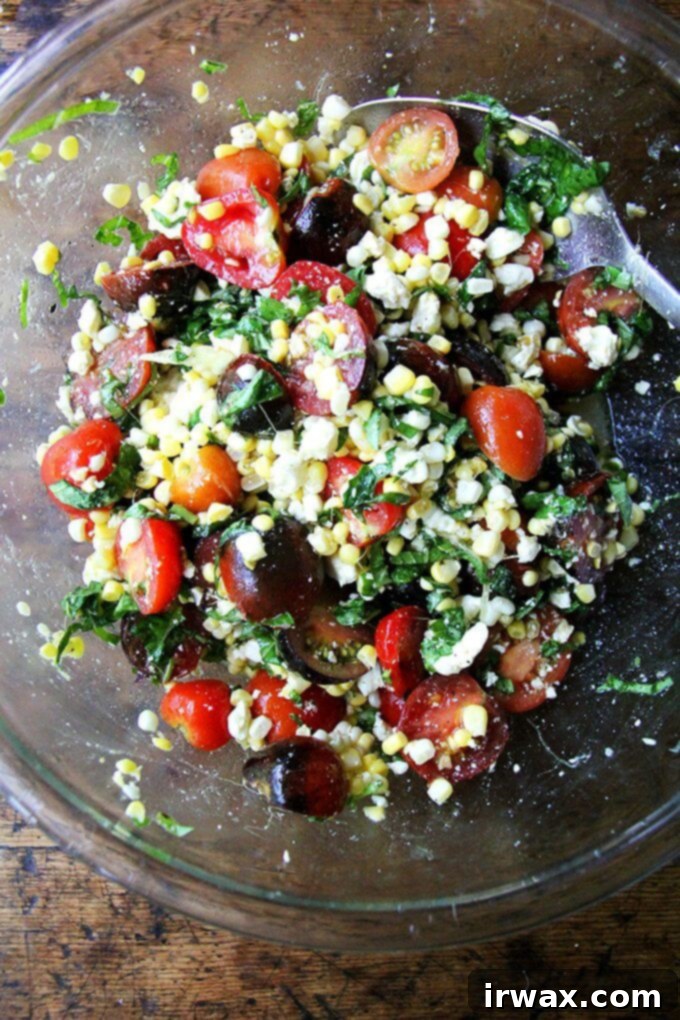 In this corn salad, raw corn doesn’t mind rubbing elbows with all of its seasonal pals. Here, it’s tomatoes and herbs, but the simple formula could be riffed on endlessly: diced bell peppers, cilantro, scallions, cubes of raw zucchini or roasted eggplant, diced mozzarella, Cheddar or Monterey Jack cheese would all work well here. // alexandracooks.com Ένα μπολ με σαλάτα από ωμό καλαμπόκι, ντομάτες και φέτα.