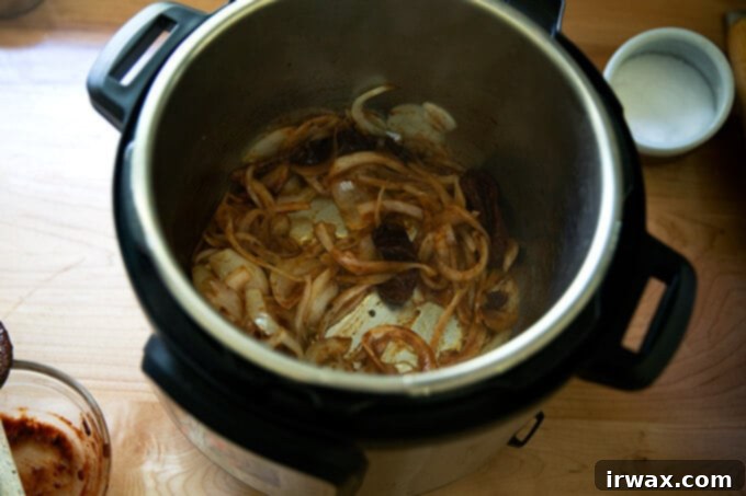 Κοτόπουλο Τίνγκα της Στιγμής 6 Μια Instant Pot γεμάτη με σοταρισμένα κρεμμύδια και chipotle σε σάλτσα adobo.