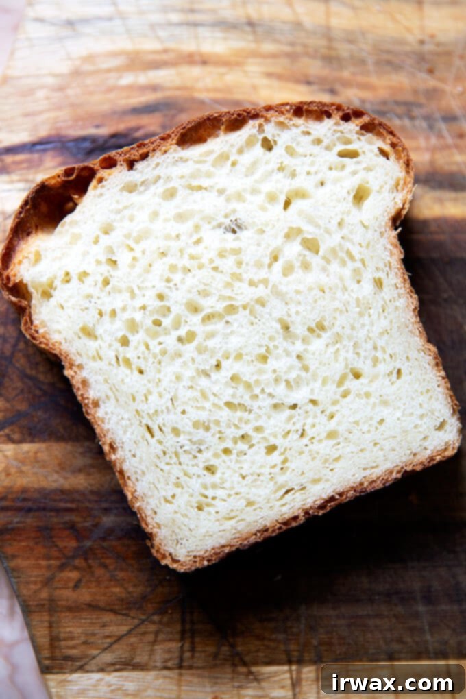 Εύκολο Μπριός Χωρίς Ζύμωμα 16 Μια φέτα ψωμί brioche σε ξύλο κοπής.