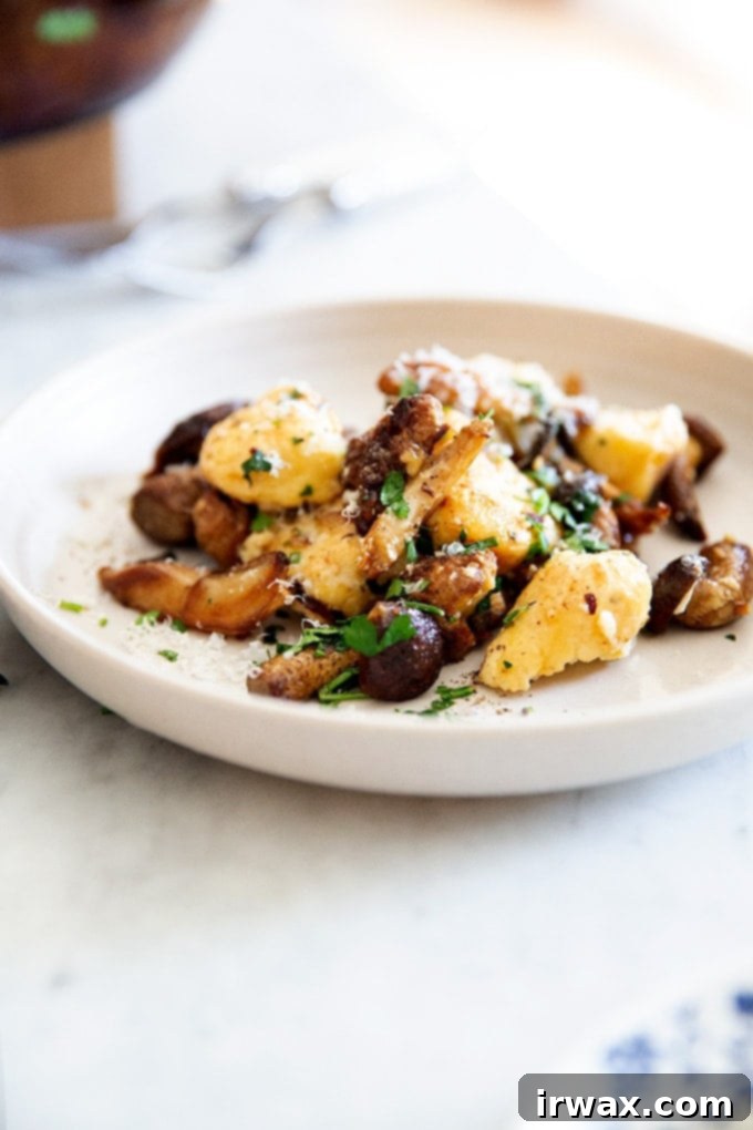 Εύκολα Σπιτικά Νιόκι με Ρικότα 29 Ένα πιάτο με gnocchi ricotta ανακατεμένα με μανιτάρια σε καφέ βούτυρο.