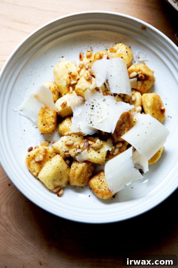 Εύκολα Σπιτικά Νιόκι με Ρικότα 32 Ένα μπολ με gnocchi σε καφέ βούτυρο ανακατεμένα με φρυγανισμένα κουκουνάρια και παρμεζάνα.