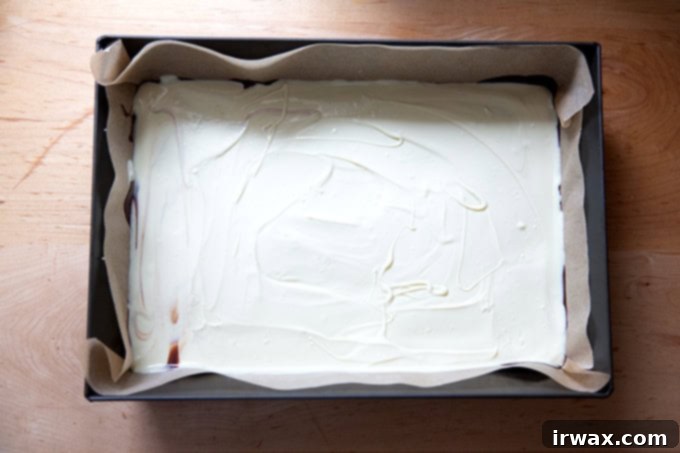 Μέντα Φλοιός με Σκόνη Μέντας 13 A layer of melted white chocolate spread over a layer of dark chocolate in a 10x14-inch pan.