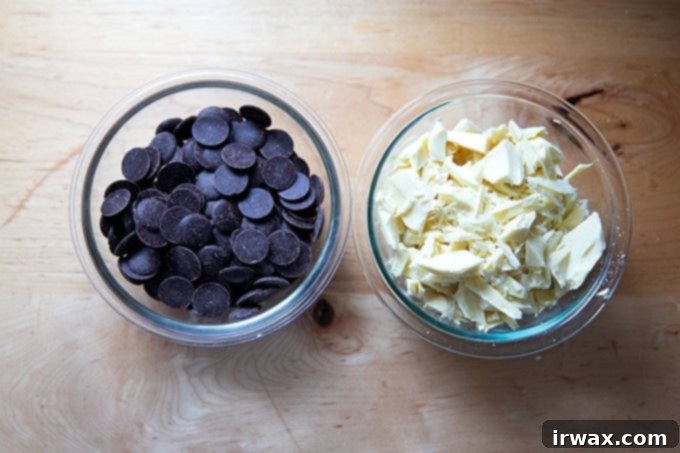 Μέντα Φλοιός με Σκόνη Μέντας 6 Two bowls of chocolate: one of dark chocolate disks, the other of chopped white chocolate.
