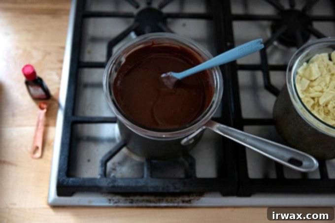 Μέντα Φλοιός με Σκόνη Μέντας 8 A bowl of melted dark chocolate set over a pot of boiling water on the stovetop.