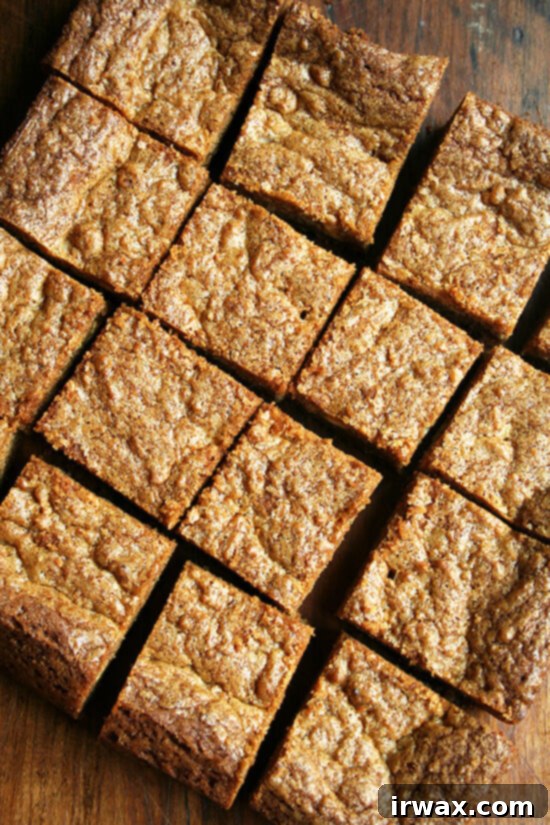 Για μένα, αυτά τα blondies με καραμελωμένο βούτυρο είναι ο παράδεισος, μια τέλεια ισορροπία γλυκού και αλμυρού, αδύνατο να μην τα τσιμπολογάς όλη μέρα. Το καραμελωμένο βούτυρο προσφέρει όλη την ξηροκαρπάτη και νόστιμη γεύση που υπόσχονται οι πολλοί θαυμαστές του. Είναι ιδιαίτερα απολαυστικά με ένα ποτήρι γάλα, αλλά δεν μπορώ να προσποιηθώ ότι δεν τα έχω απολαύσει και δίπλα στον πρωινό καφέ και το απογευματινό τσάι. // alexandracooks.com Κομμένα blondies με καραμελωμένο βούτυρο σε έναν πίνακα.